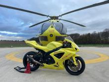 Photo of yellow motorcycle in front of yellow helicopter